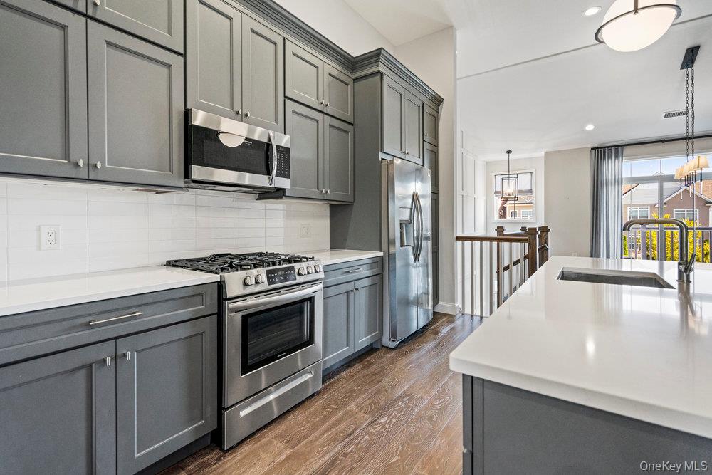 295 Silver Timber Drive Yaphank, NY 11980 - Photo 5 of 50 a kitchen with stainless steel appliances granite countertop a stove a sink and a refrigerator