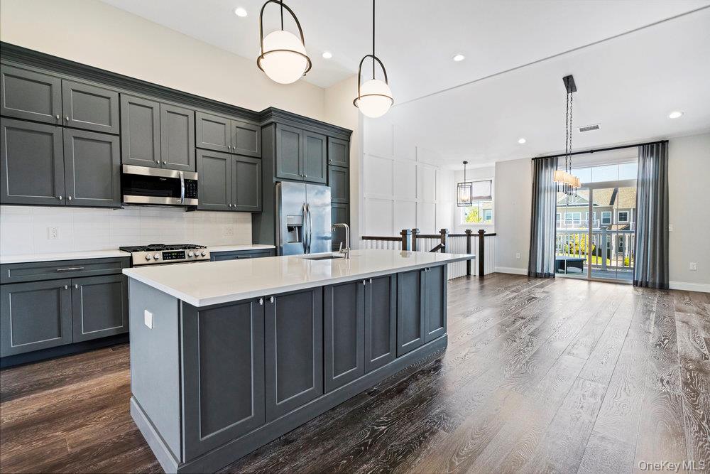 295 Silver Timber Drive Yaphank, NY 11980 - Photo 7 of 50 a kitchen with a sink microwave and cabinets