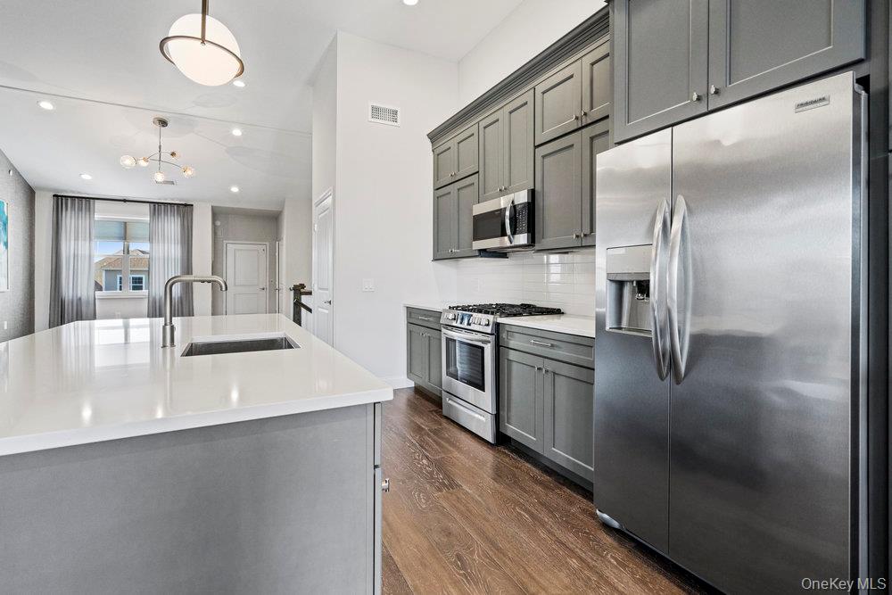 295 Silver Timber Drive Yaphank, NY 11980 - Photo 8 of 50 a kitchen with stainless steel appliances granite countertop a sink a stove and a refrigerator