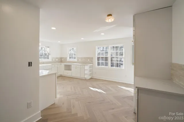 a view of a kitchen with wooden floor and windows