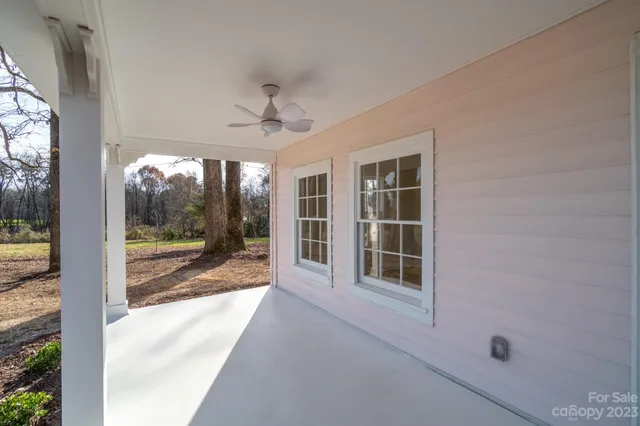 a view of a porch with furniture and floor to ceiling window