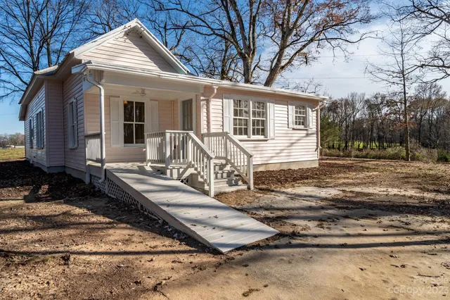 a view of a house with backyard and trees