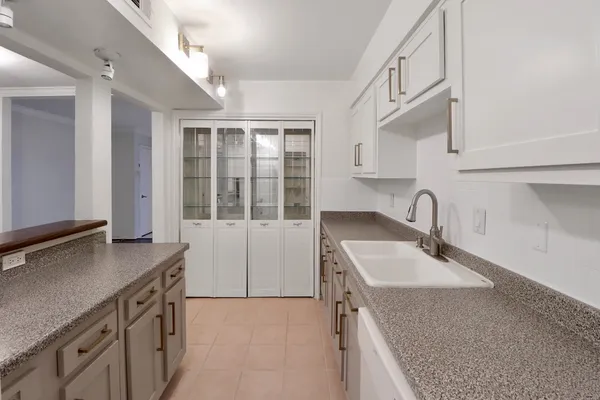 a bedroom with a large bed a chandelier and a window