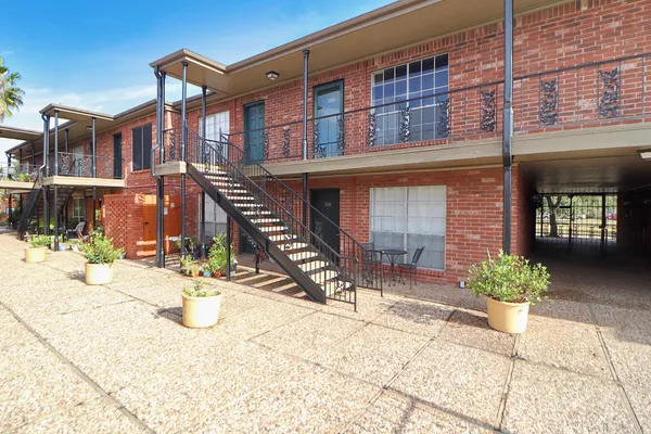 a view of a hallway with wooden floor and a ceiling fan