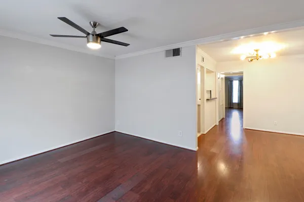 a view of an empty room with wooden floor