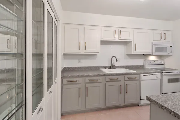 a kitchen with white cabinets and a sink