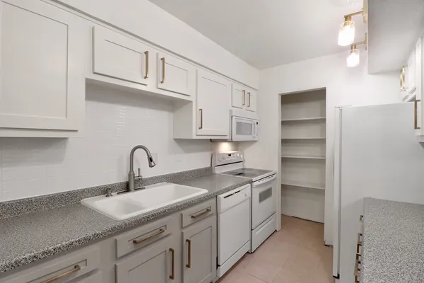 a kitchen with stainless steel appliances granite countertop a refrigerator and a sink