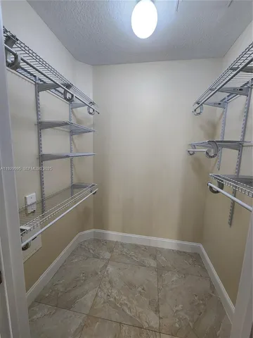 a view of a brick house with large windows and a small yard