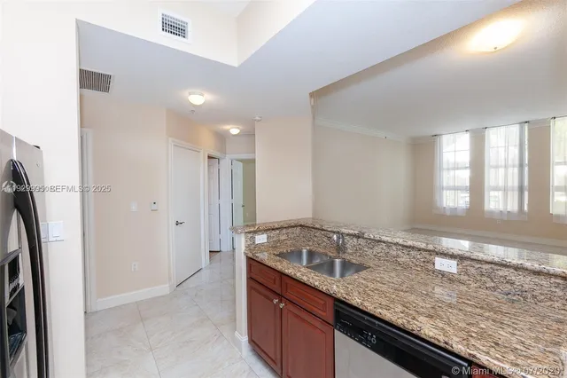 a kitchen with granite countertop a sink and a refrigerator