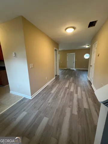 a view of an empty room and chandelier fan