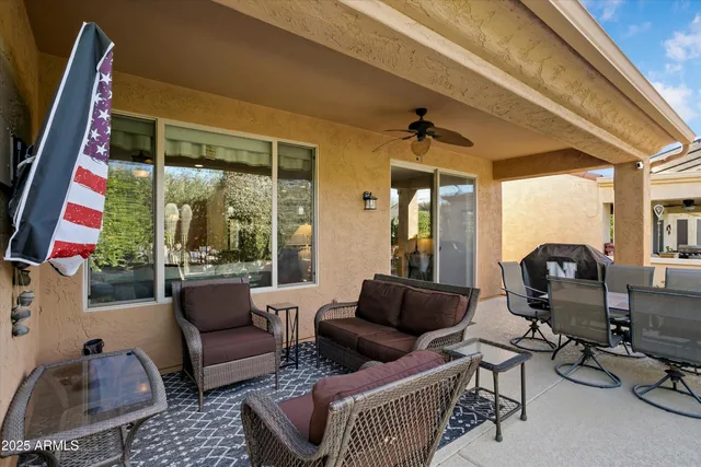 a view of a patio with couches a table and chairs and potted plants