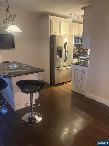 a kitchen with kitchen island stainless steel appliances a sink refrigerator stove and microwave