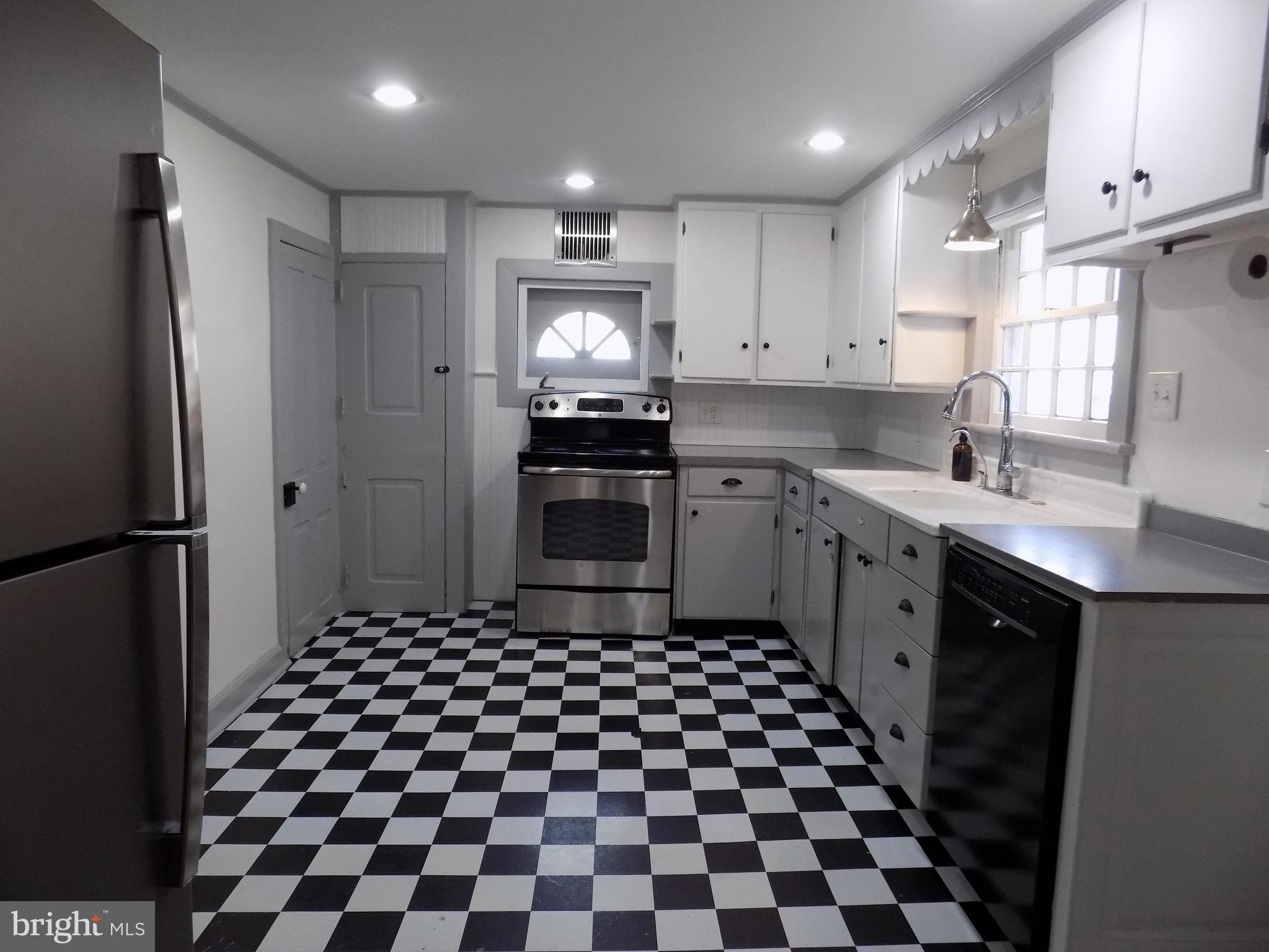3103 Bedminster Road Ottsville, PA 18942 - Photo 7 of 22 a kitchen with a checkered floor and white cabinets