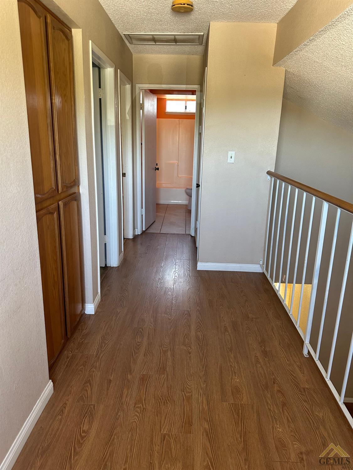 Undisclosed Address Bakersfield, CA 93313 - Photo 15 of 30 a view of a hallway with wooden floor and staircase