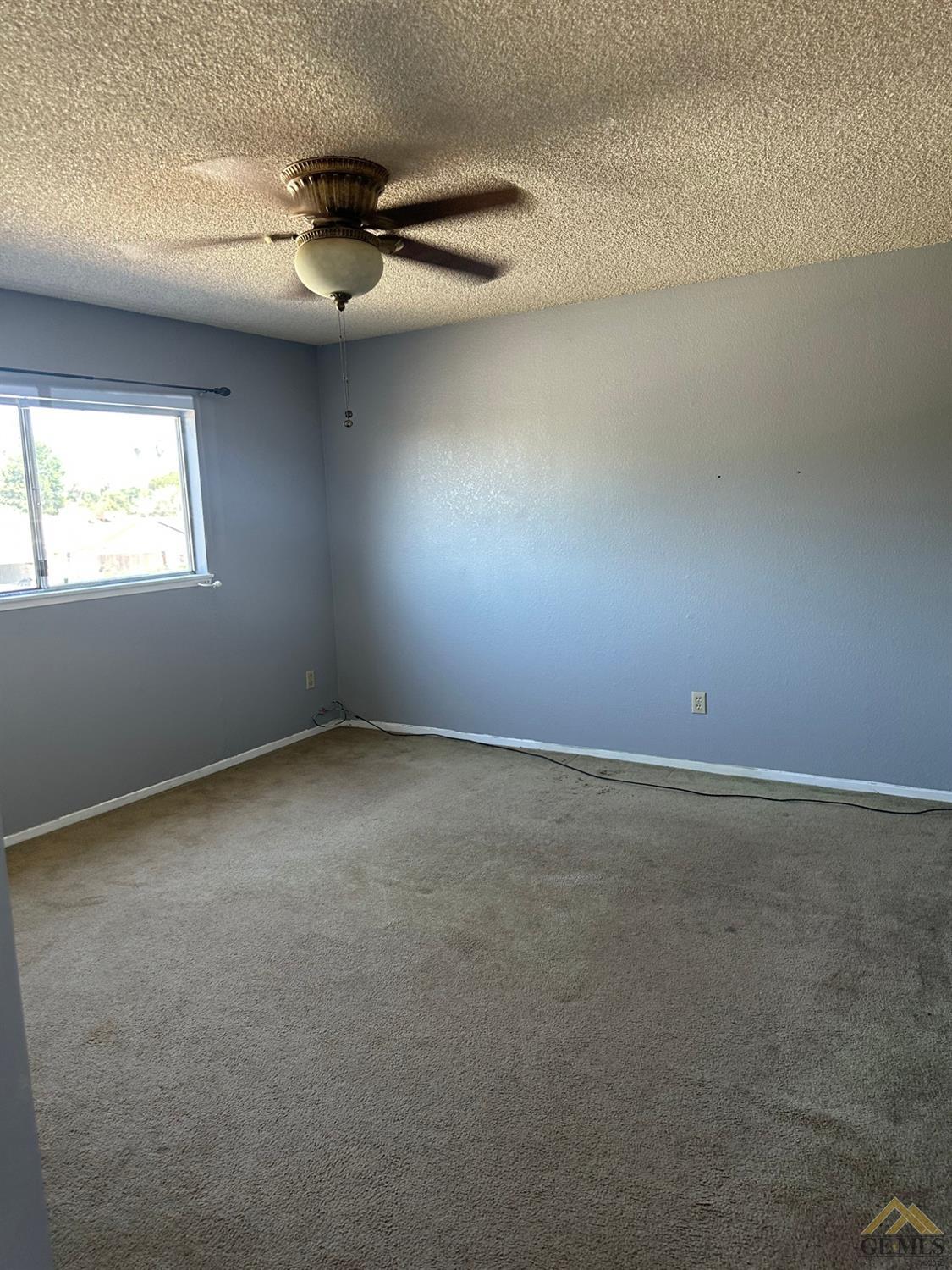 Undisclosed Address Bakersfield, CA 93313 - Photo 16 of 30 an empty room with a ceiling fan and window