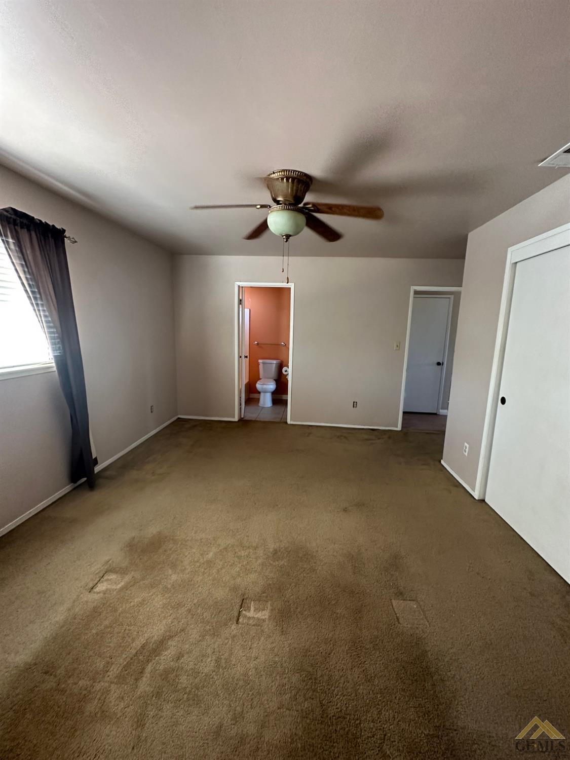 Undisclosed Address Bakersfield, CA 93313 - Photo 19 of 30 an empty room with windows and chandelier fan