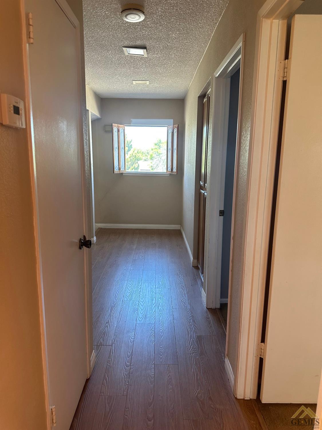 Undisclosed Address Bakersfield, CA 93313 - Photo 21 of 30 an empty room with wooden floor and a window