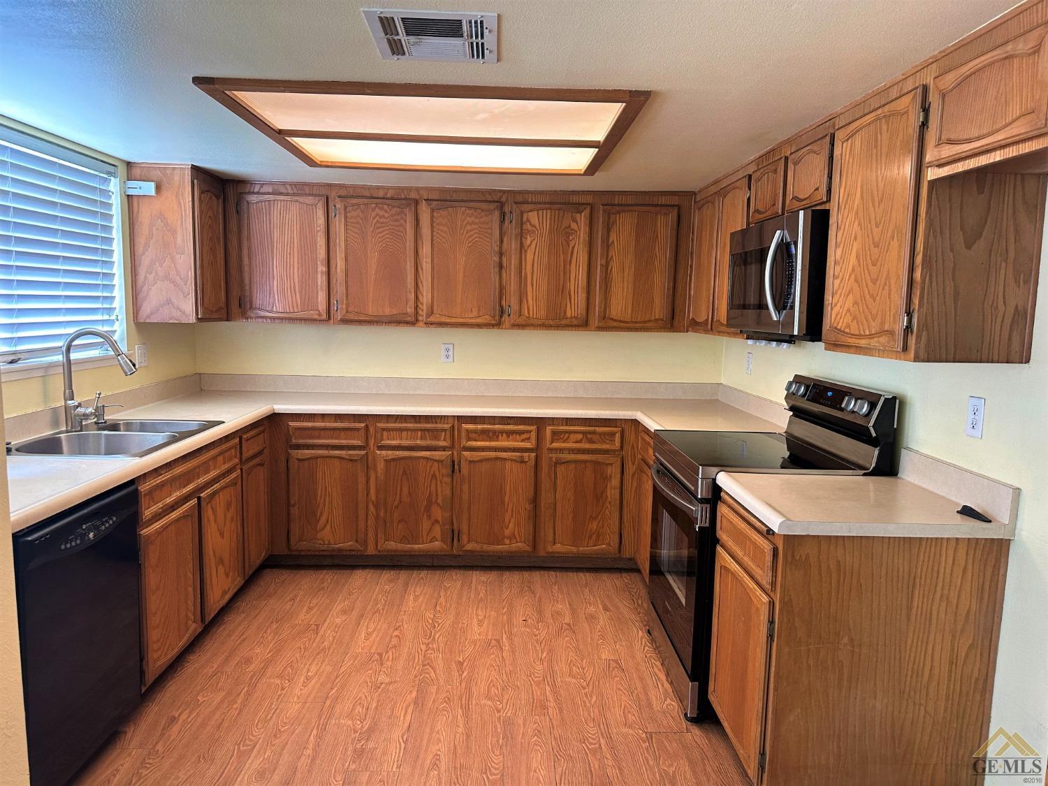 Undisclosed Address Bakersfield, CA 93313 - Photo 6 of 30 a kitchen with a sink and wooden cabinets