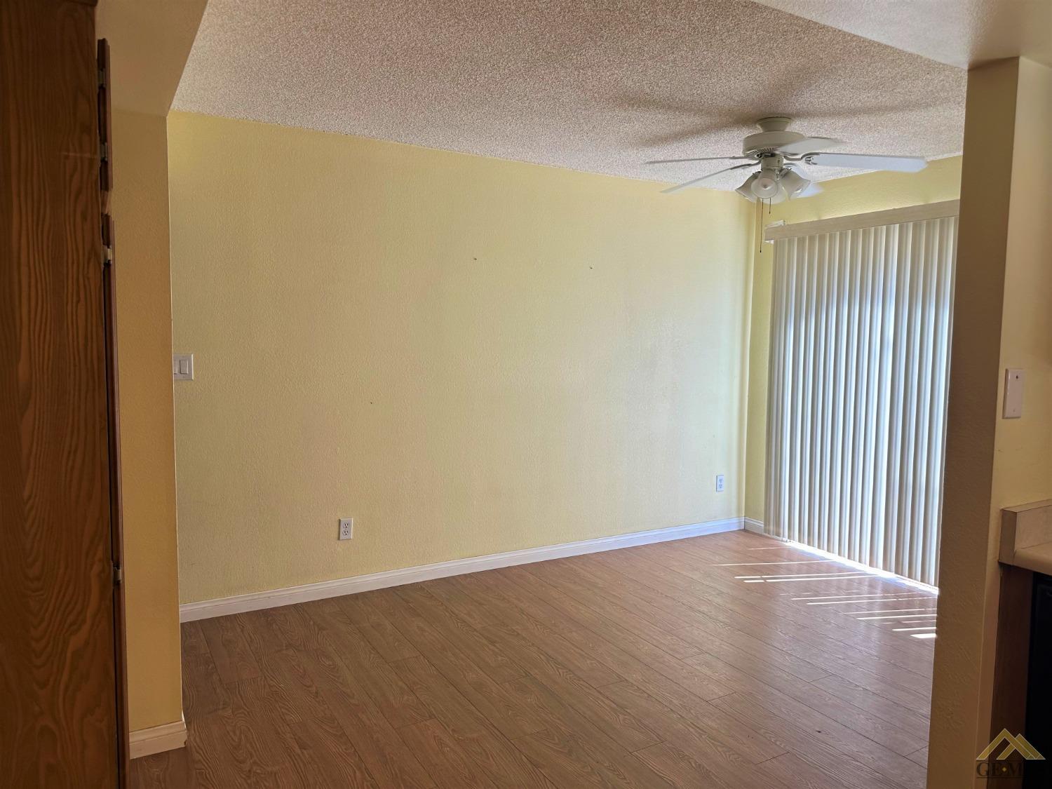 Undisclosed Address Bakersfield, CA 93313 - Photo 7 of 30 an empty room with wooden floor fan and windows