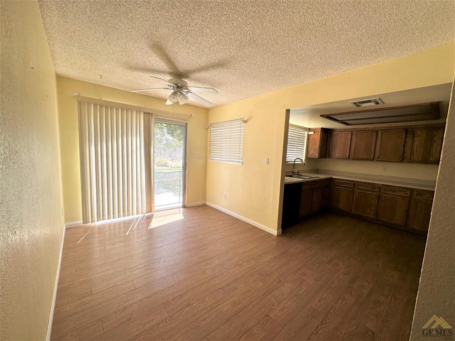 Undisclosed Address Bakersfield, CA 93313 - Photo 8 of 30 a view of a kitchen with a stove cabinets and a ceiling fan