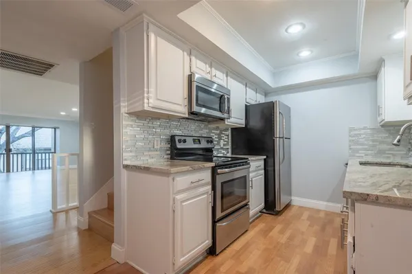 a kitchen with stainless steel appliances granite countertop a stove a refrigerator and a microwave