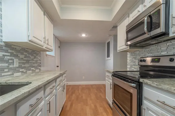 a kitchen with stainless steel appliances granite countertop a stove a sink and a microwave