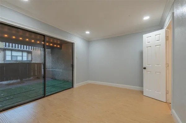 en empty room with sliding door and wooden floor