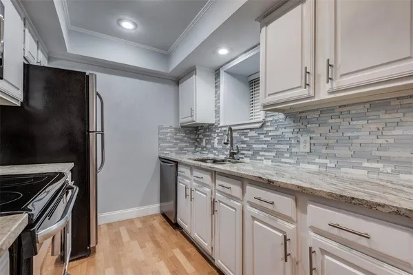 a kitchen with stainless steel appliances granite countertop a refrigerator and a sink