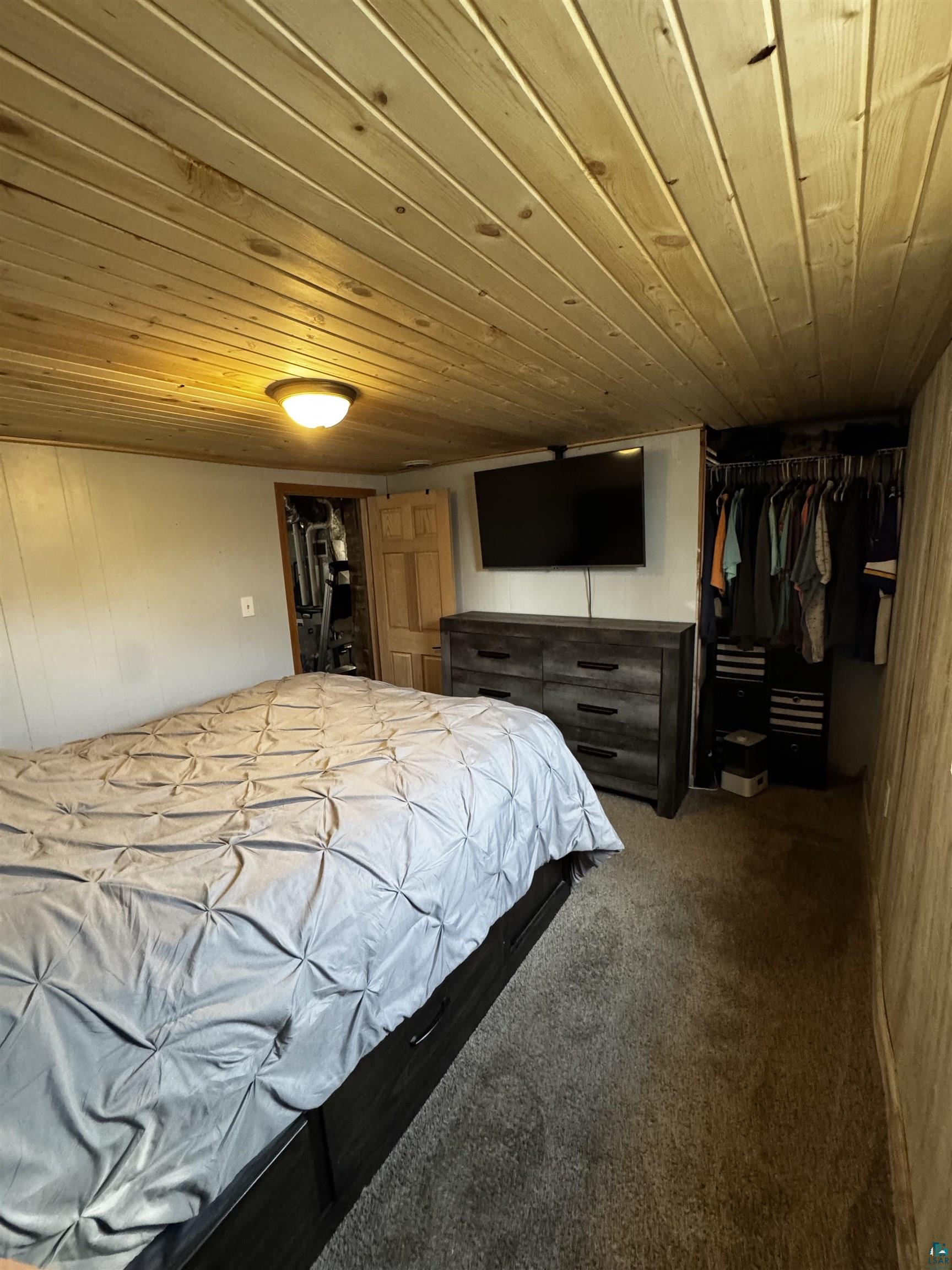 516 14th Street Cloquet, MN 55720 - Photo 28 of 30 Bedroom with wooden ceiling, dark colored carpet, and wood walls
