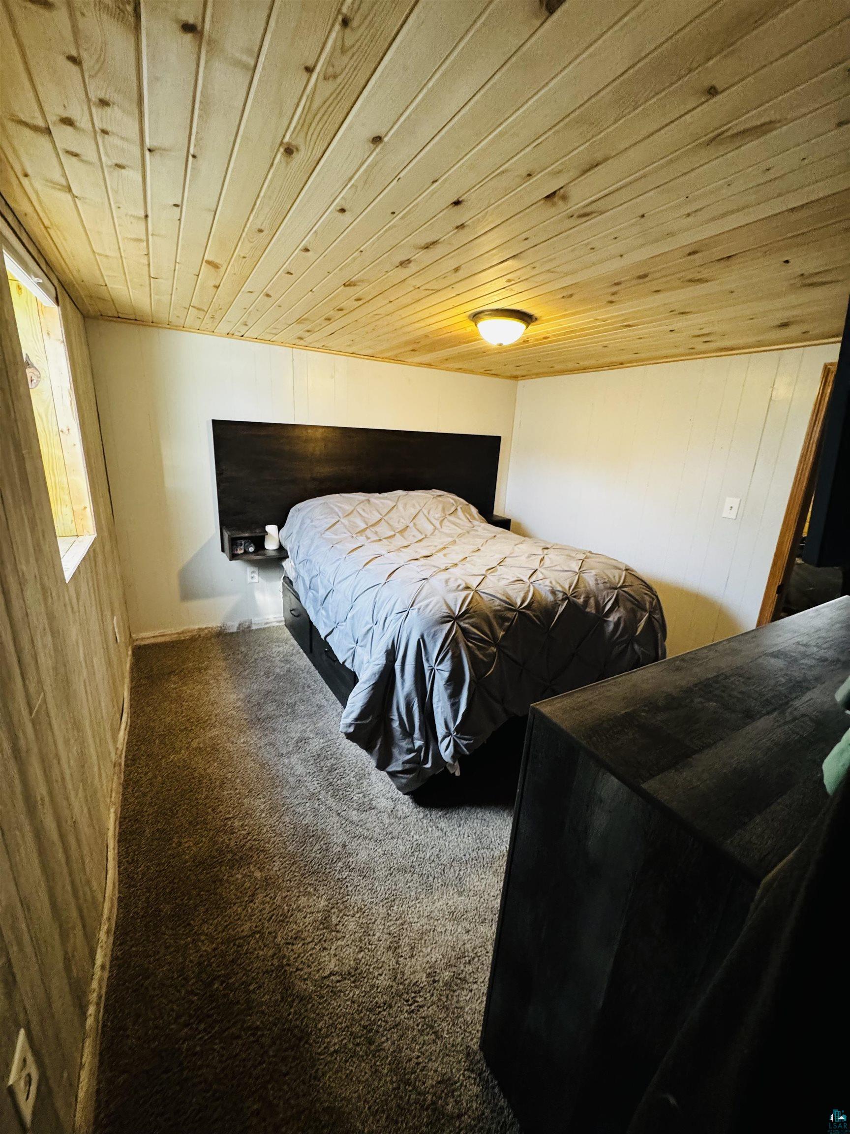 516 14th Street Cloquet, MN 55720 - Photo 29 of 30 Bedroom with wooden walls, wooden ceiling, and carpet floors
