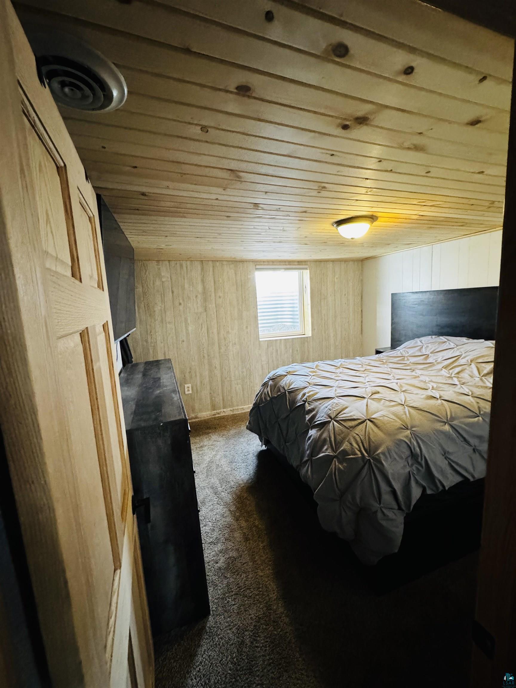516 14th Street Cloquet, MN 55720 - Photo 30 of 30 Bedroom with dark carpet, wooden walls, and wooden ceiling