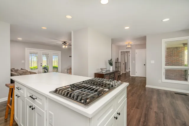 a kitchen with granite countertop white cabinets and white appliances