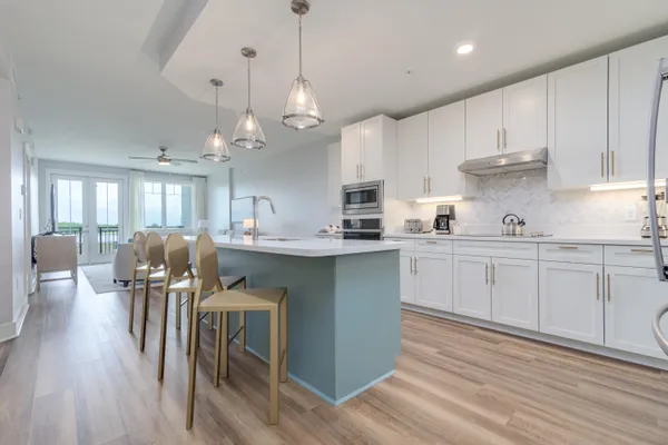 a kitchen with stainless steel appliances kitchen island granite countertop a table chairs and a refrigerator