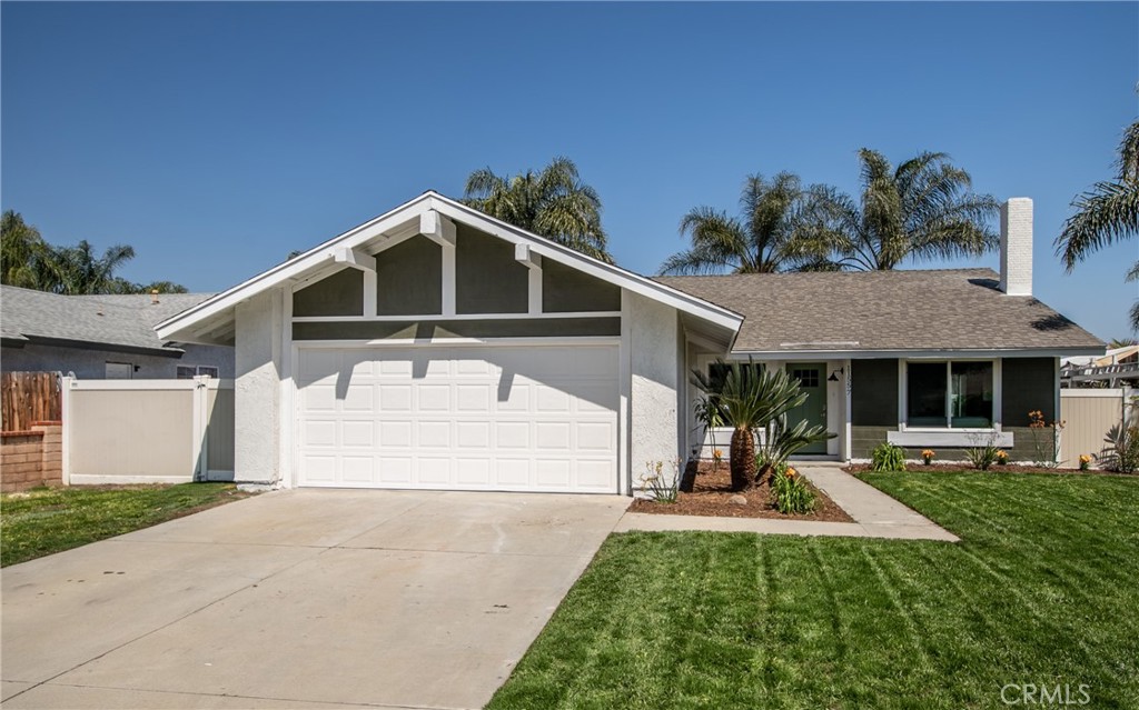 a view of a house with a yard potted plants and a bench