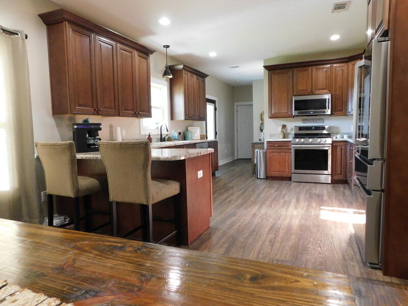 5856 Bush Road Baker, FL 32531 - Photo 5 of 57 a kitchen with stainless steel appliances wooden floors and wooden cabinets