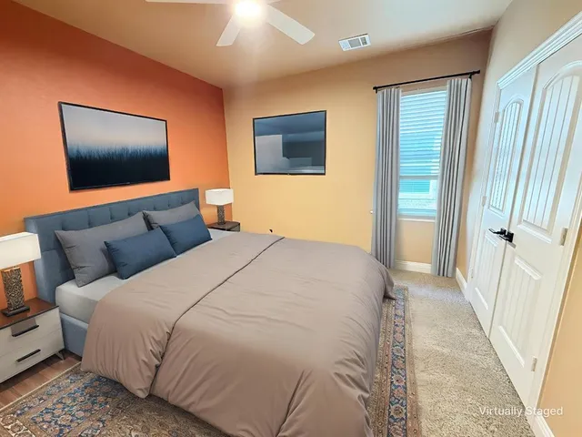 a bedroom with a bed a couch and a flat screen tv