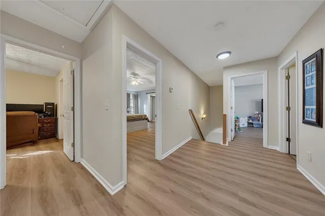 a view of a hallway with wooden floor and a living room