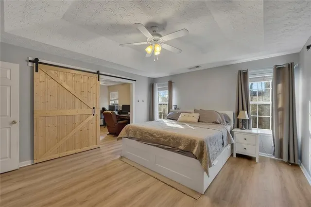 a spacious bedroom with a bed a chandelier and a window