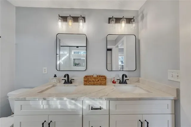 a bathroom with a double vanity sink mirror and toilet