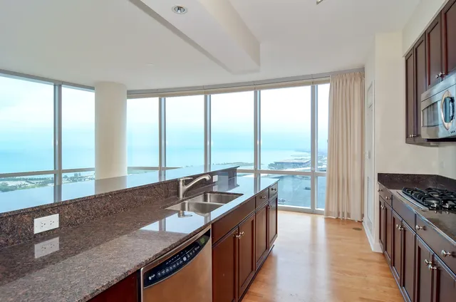 a kitchen with stainless steel appliances granite countertop a sink a stove and a refrigerator