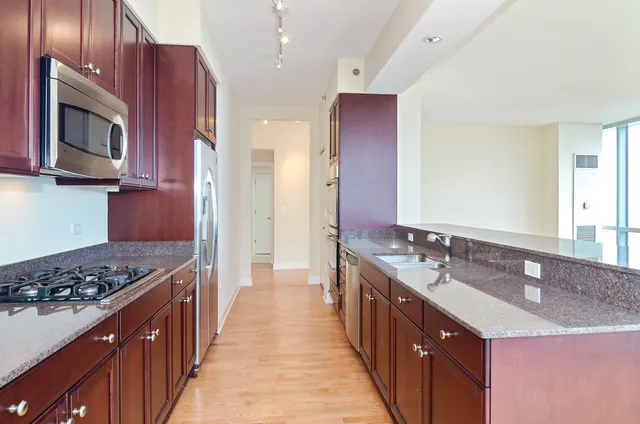 a kitchen with stainless steel appliances a sink stove and cabinets