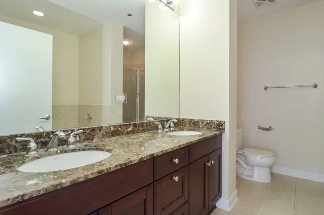 a bathroom with a granite countertop sink and a mirror with toilet