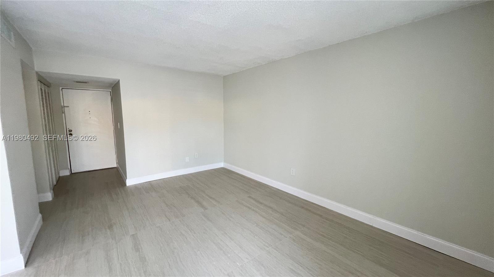 9331 Southwest 4th Street, Unit 101A Miami, FL 33174 - Photo 2 of 15 a view of an empty room with wooden floor and closet