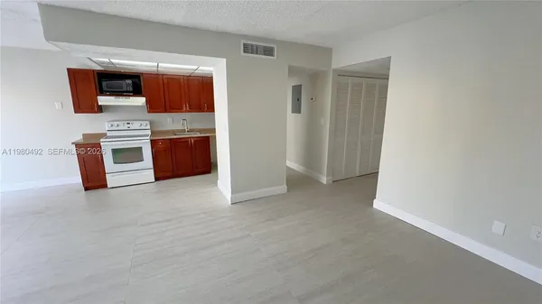 a view of kitchen with stainless steel appliances wooden floor and window