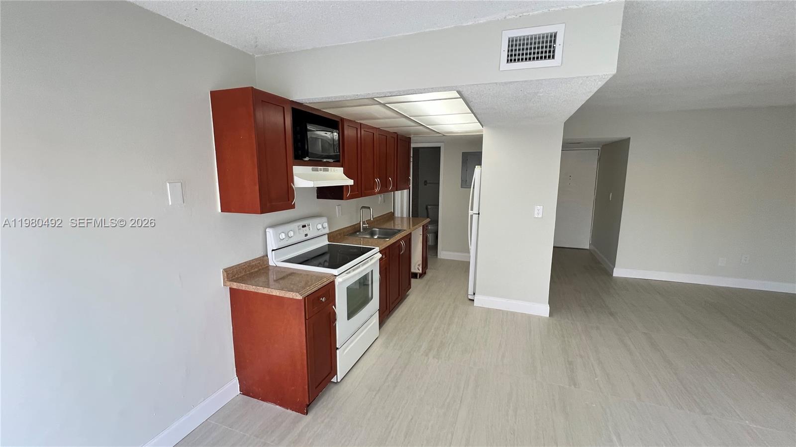 9331 Southwest 4th Street, Unit 101A Miami, FL 33174 - Photo 6 of 15 a kitchen with stainless steel appliances granite countertop a stove and a white refrigerator