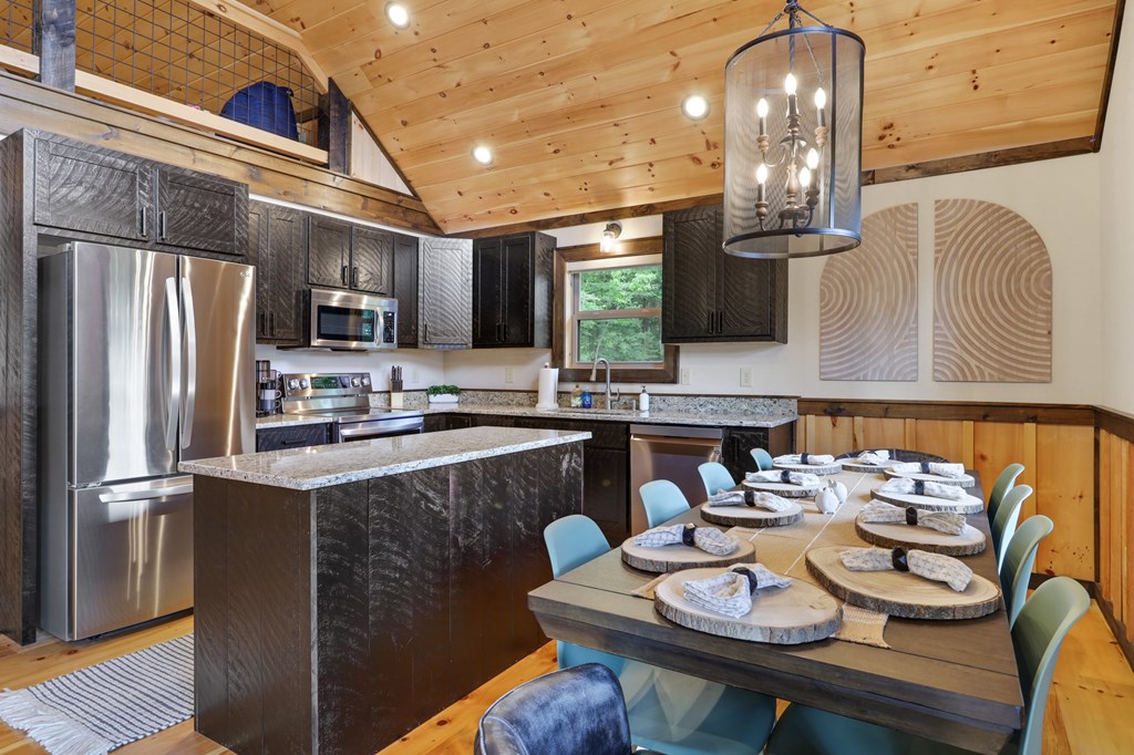 42 Old Jerusalem Road Morganton, GA 30560 - Photo 11 of 61 a kitchen with stainless steel appliances granite countertop a sink dishwasher a stove a refrigerator with a dining table and chairs