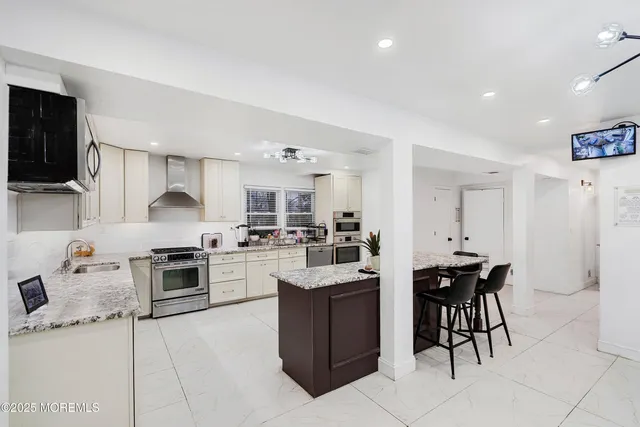 a kitchen with a sink a counter top space appliances and cabinets