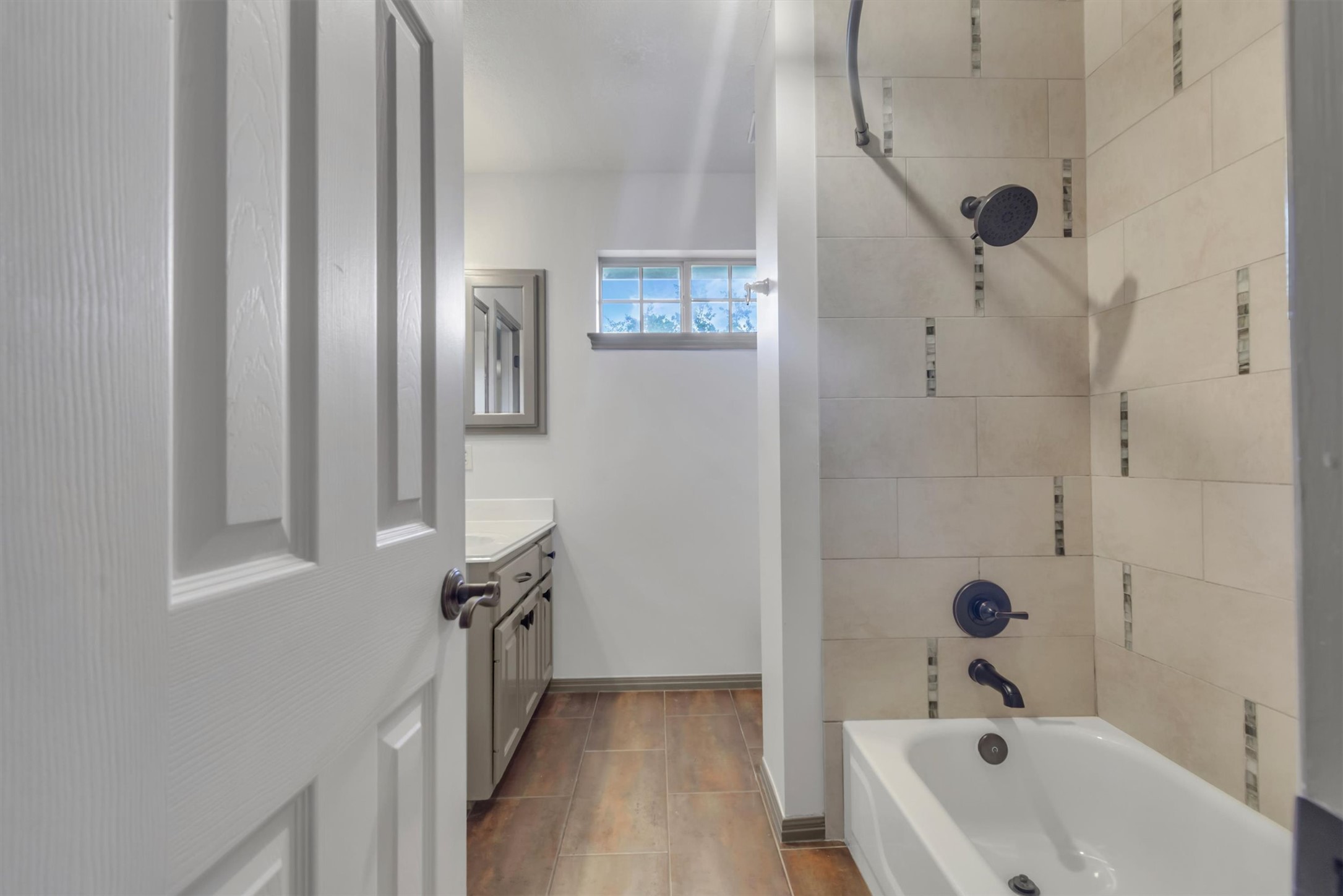 6008 Tributary Ridge Court Austin, TX 78759 - Photo 24 of 36 En-Suite bathroom to Bedroom #1. Functional bathroom features a well-maintained tub, tiled shower surround, and a vanity with ample counter space.