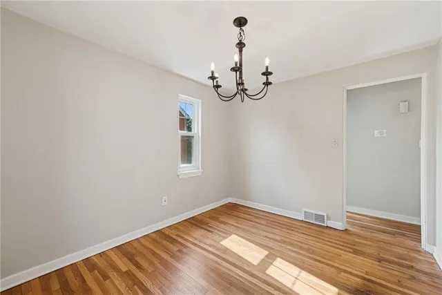 a view of a room with wooden floor and ceiling fan