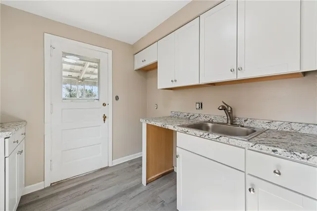 a kitchen with granite countertop white cabinets and sink